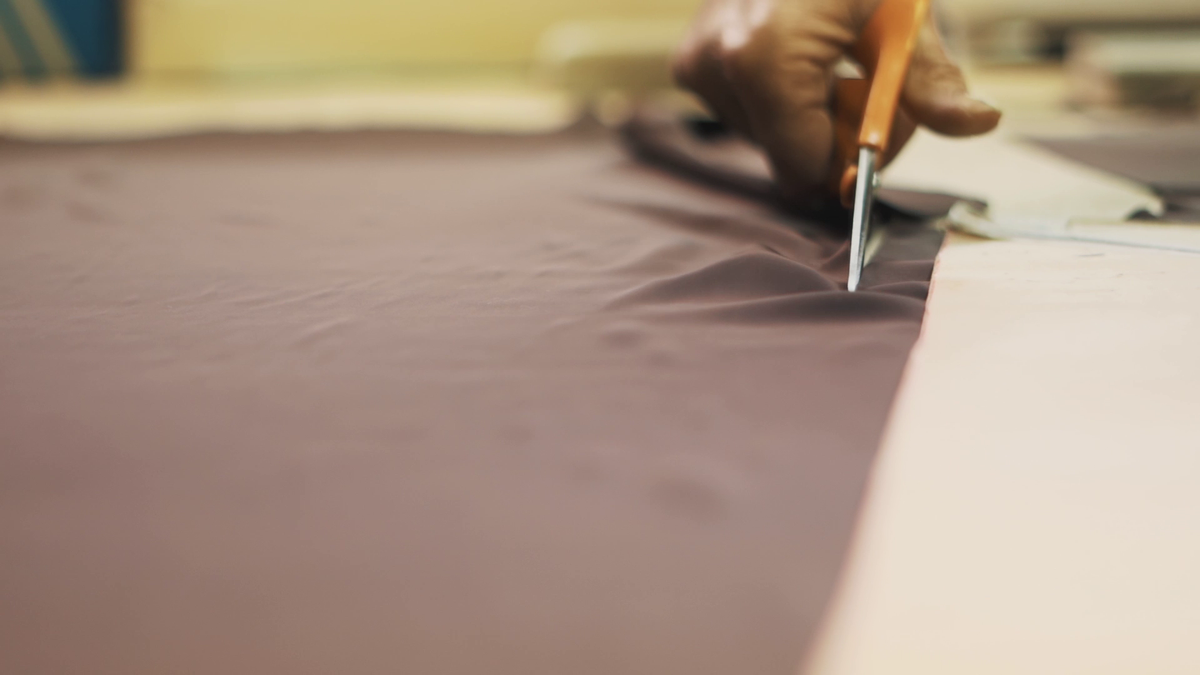 Shears cutting a panel on the workshop table at Casiani